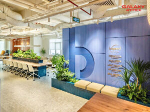 Beyond Coworking Khu vực làm việc hiện đại với tường xanh lam và cây xanh, bàn dài và ghế xoay