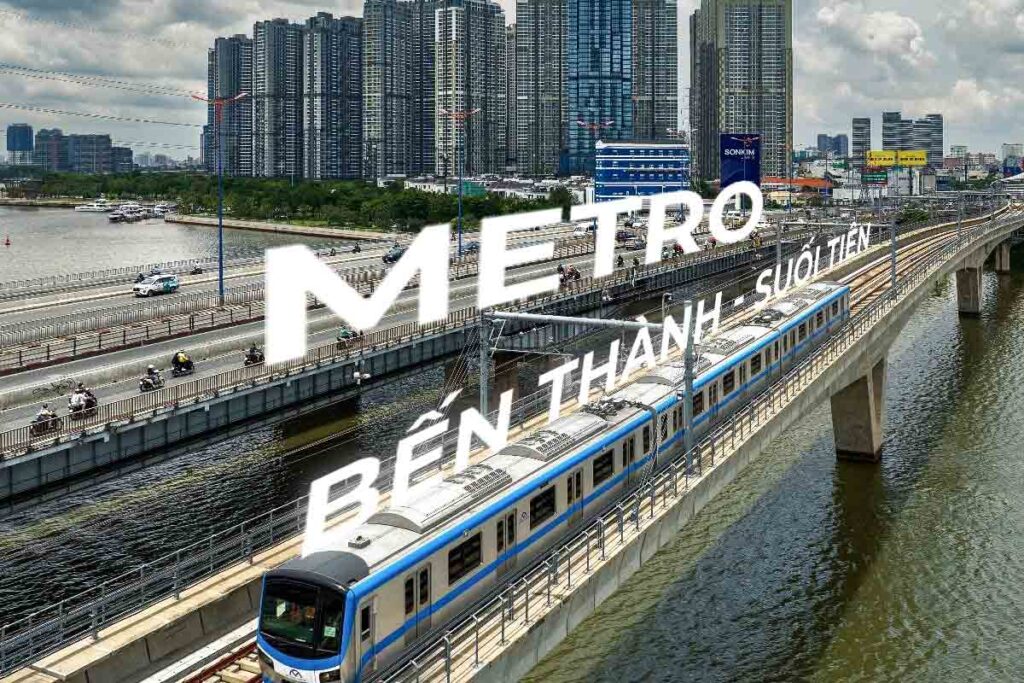 Hình ảnh tàu metro đang chạy trên cầu, với phông nền là các tòa nhà cao tầng và dòng sông, có chữ 'Metro Bến Thành - Suối Tiên' nổi bật