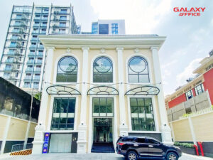 Mặt tiền ấn tượng của DATC Building với cửa sổ lớn và ô tô đậu trước cửa